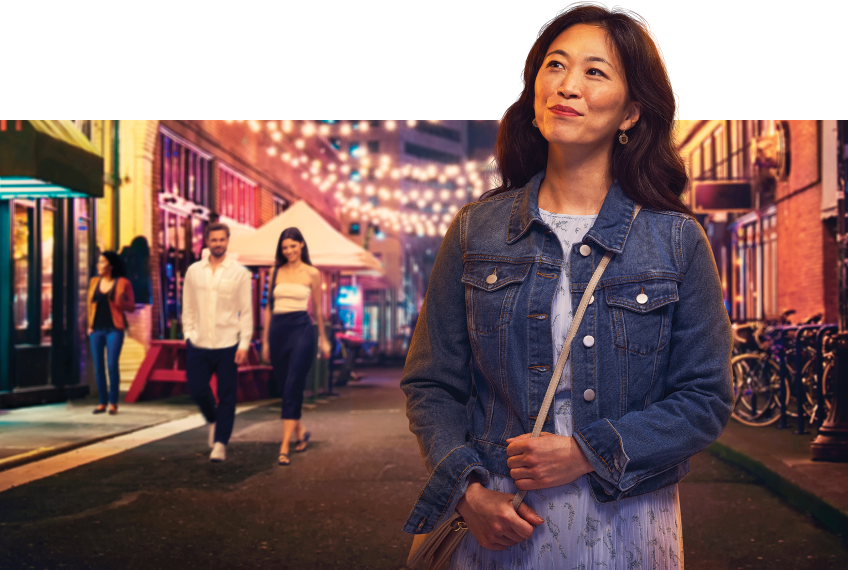 woman walking down a brightly lit street