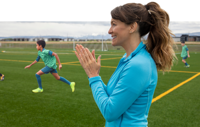 woman clapping from sidelines at a soccer game
